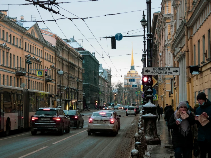 people are walking on the sidewalk in front of traffic on a city street