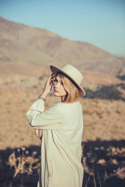 a woman in a white dress wearing a hat