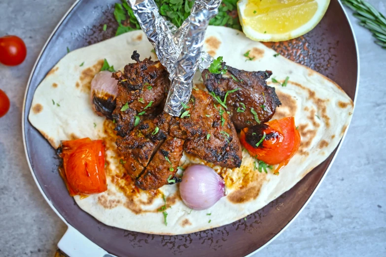 meat on a tortilla with tomatoes, onions and onions