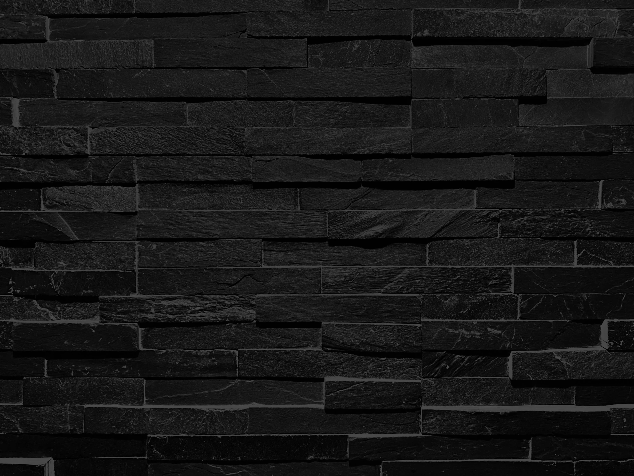 a black stone wall background textured with dark gray tile