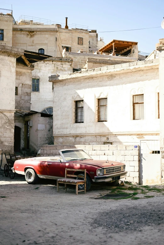 an old car is parked on the side of a building