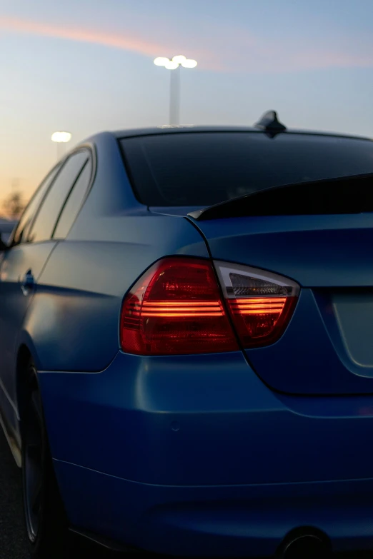 the rear end of a blue car on a street