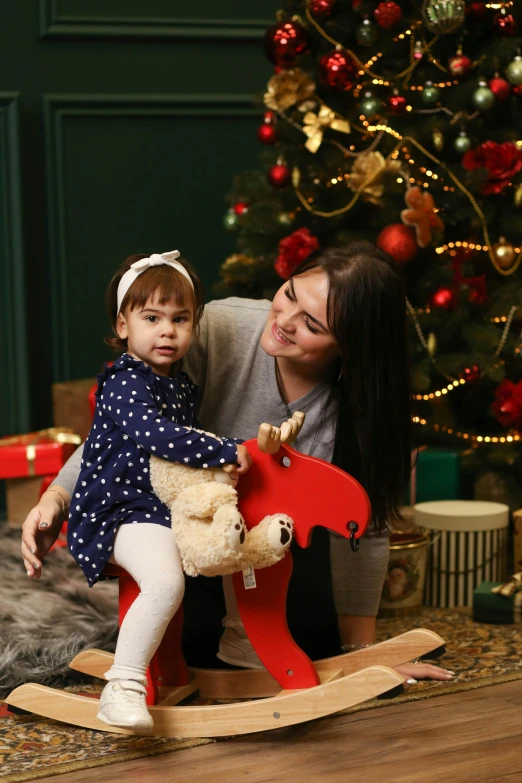 two young children sitting in front of a christmas tree