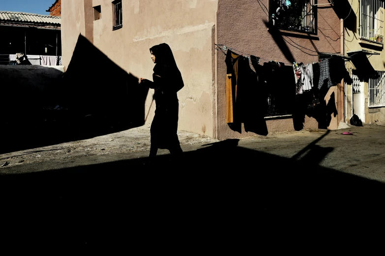 the person is walking near some clothes hanging up