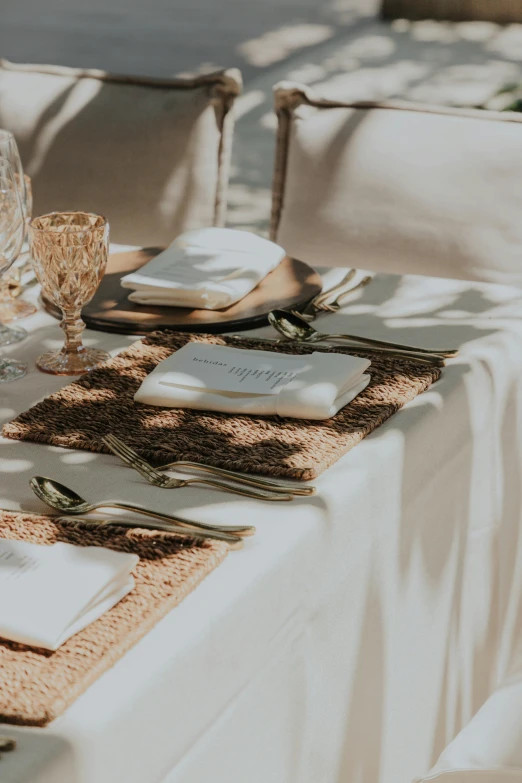 the dining table is set with gold place settings and place card holders