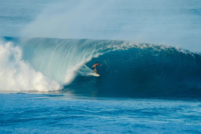 a surfer riding the huge blue wave with his surfboard