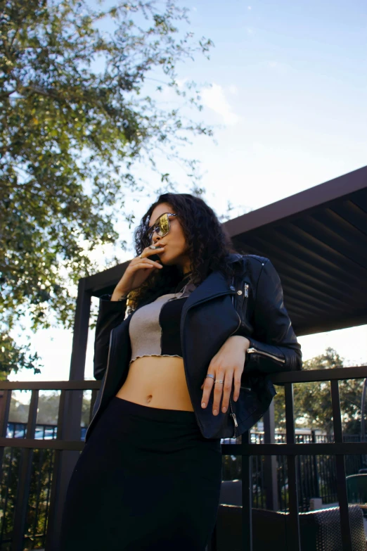 a woman that is standing in front of a fence