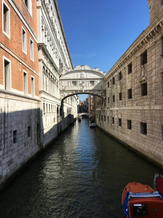 a bridge over a wide canal between two buildings