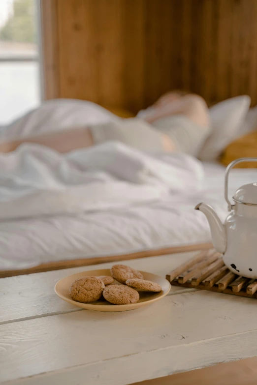 a plate with cookie on it and tea pot on the side