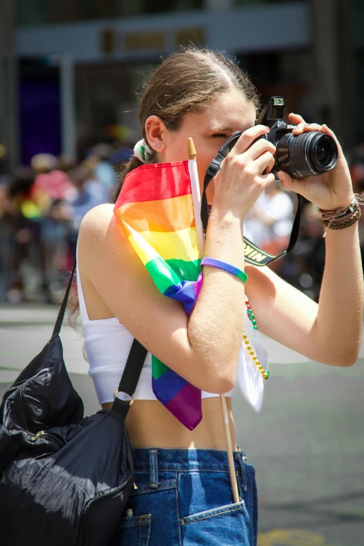 woman taking pictures with her camera of a rainbow flag