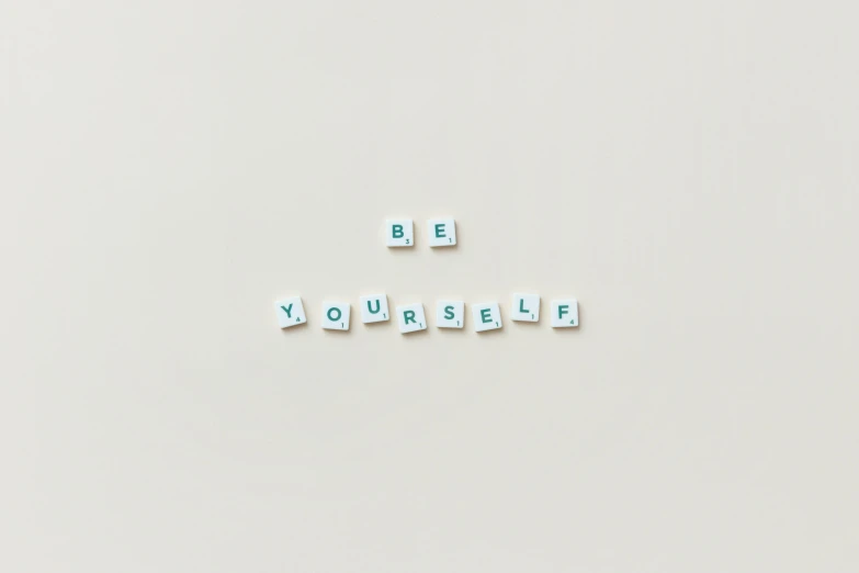 a close up of several small magnets with the letters be yourself spelled in it