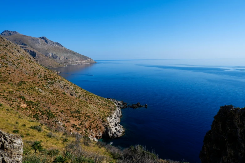 a large cliff with grass growing on the side of it