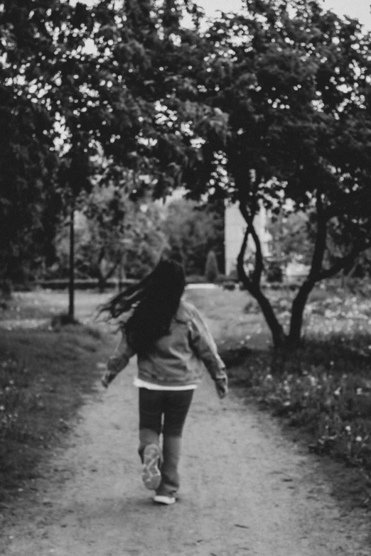 a girl walking along a path near trees