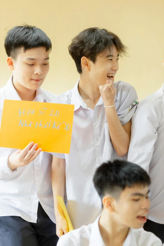 four men standing together in front of a yellow sign