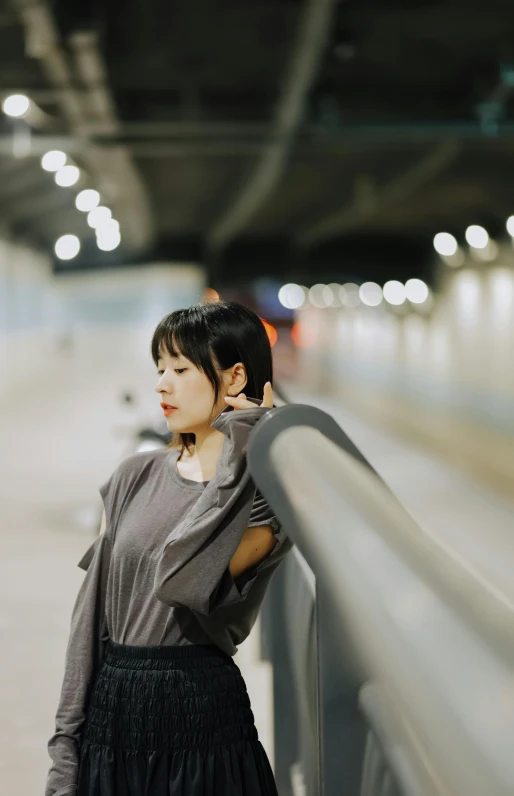 woman posing by rail during night in the city