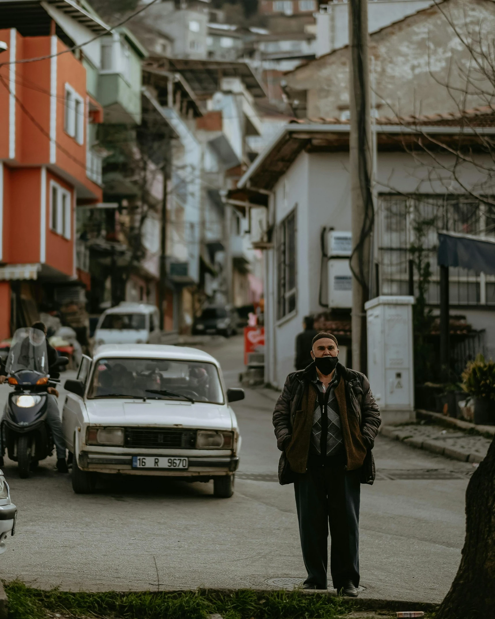 man standing in front of a car talking on a cell phone