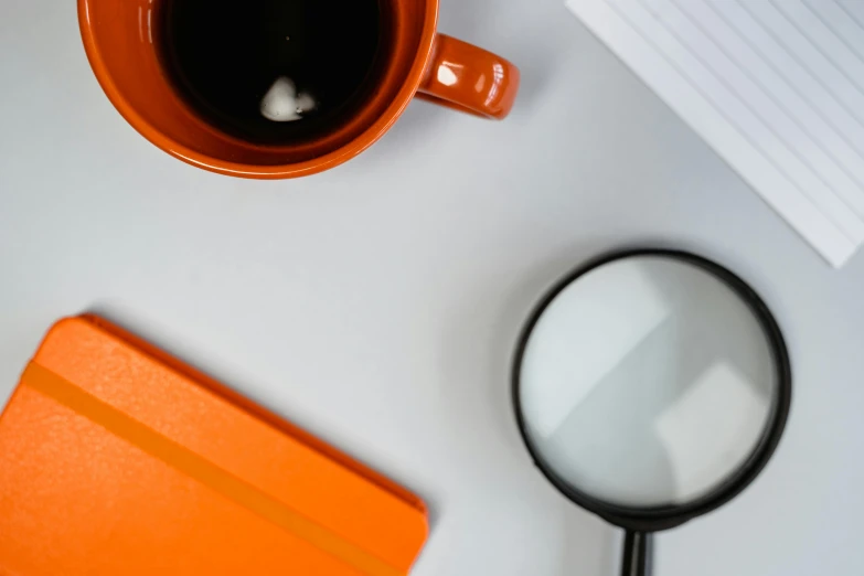 view of cup of coffee and reading material on desk