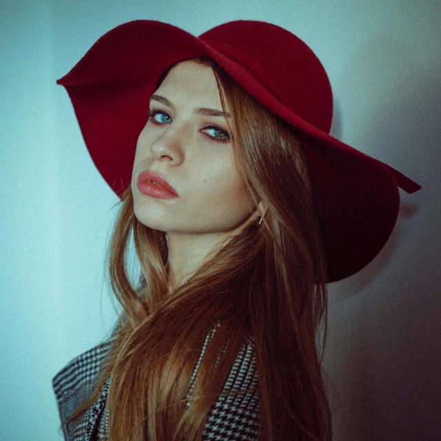 the young lady is wearing a red hat and looks at the camera