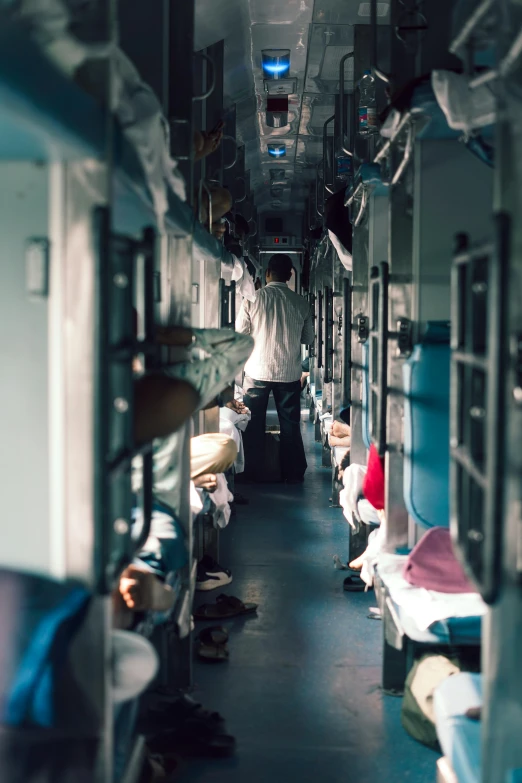 man standing in train car with lots of beds