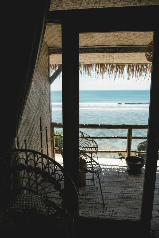 an open door on a house with view of ocean and beach