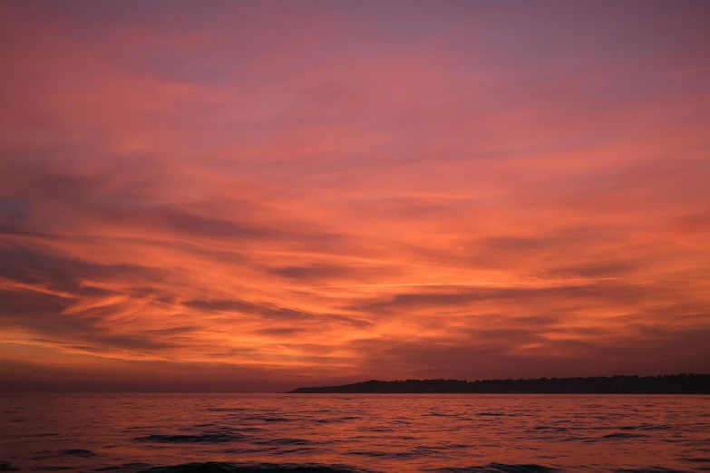 the sky is purple and orange over the water