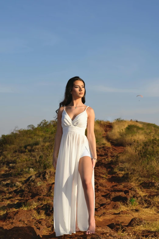 a young woman is posing by the rocks