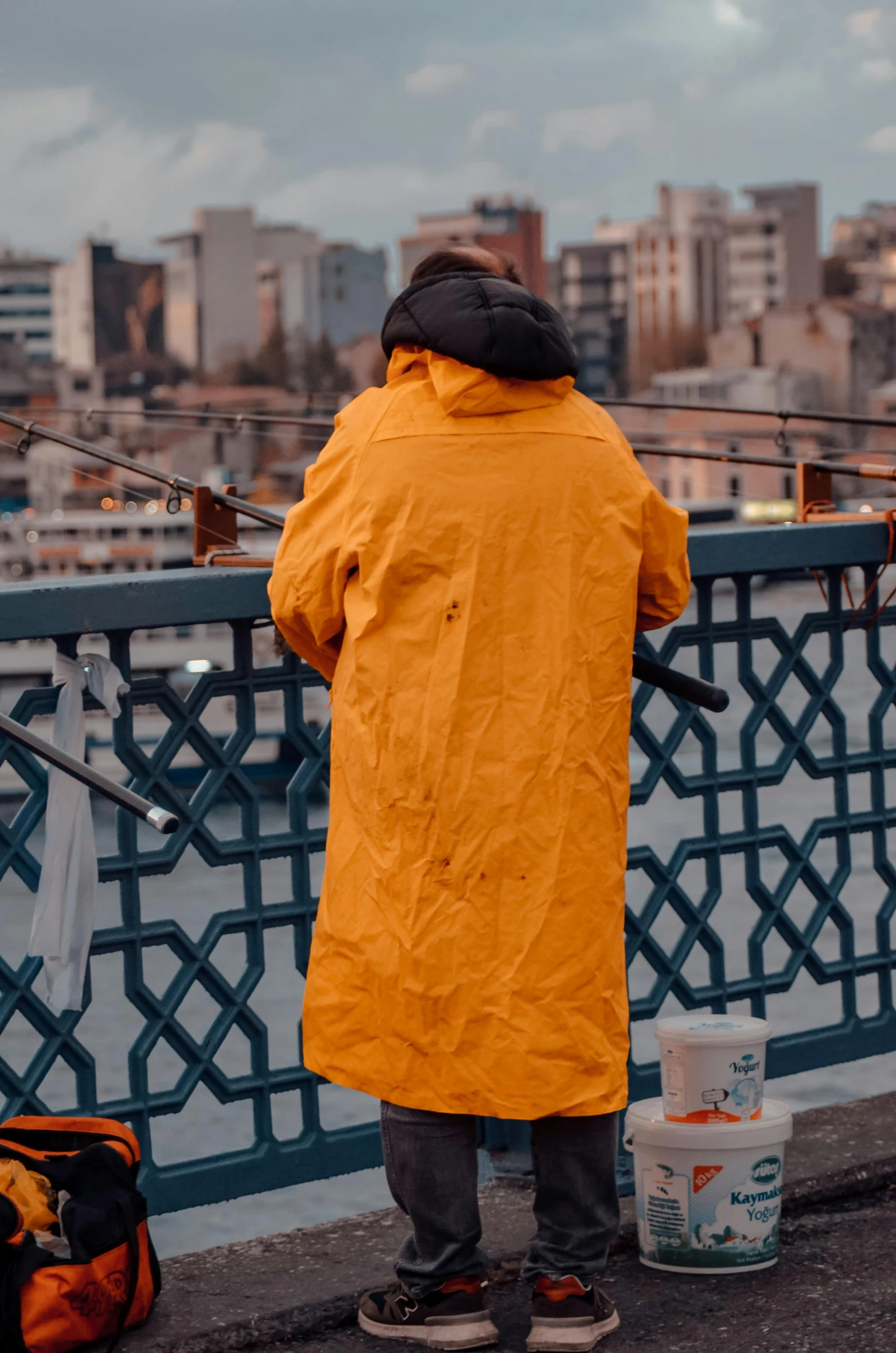 the man is standing on the side of the bridge