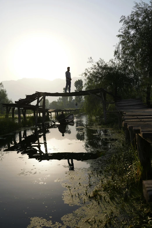 the person is crossing the bridge over the water