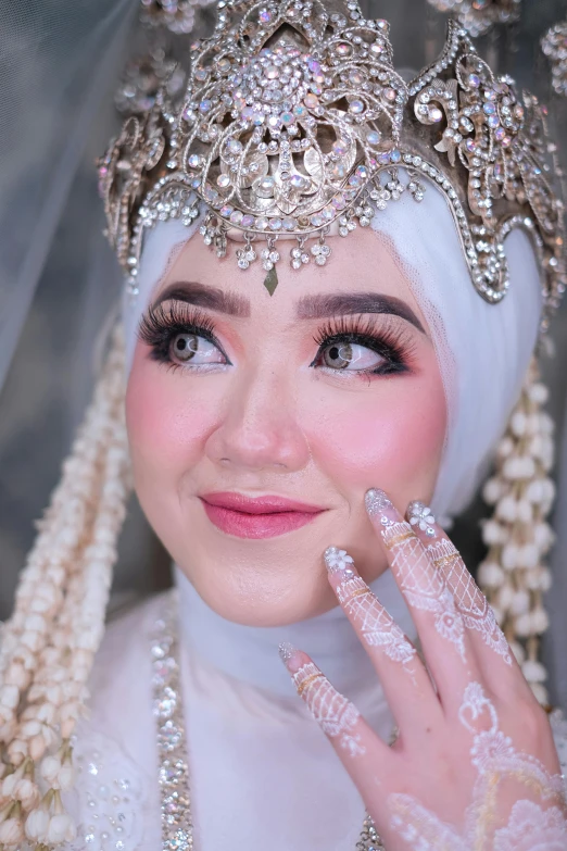 a beautiful woman with long nails and a white veil