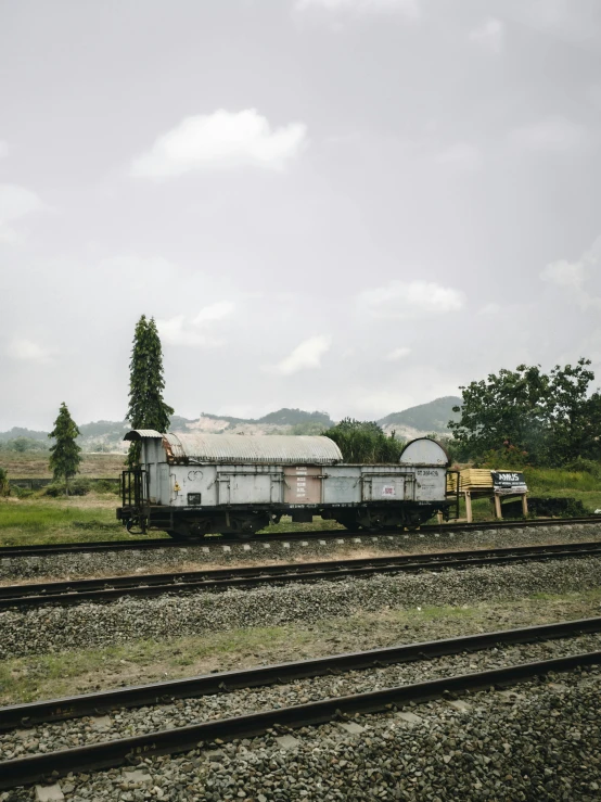 an abandoned train engine on some tracks in a field