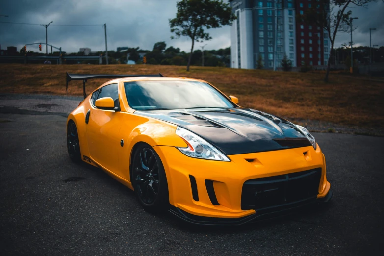 a yellow car with a black strip on its hood