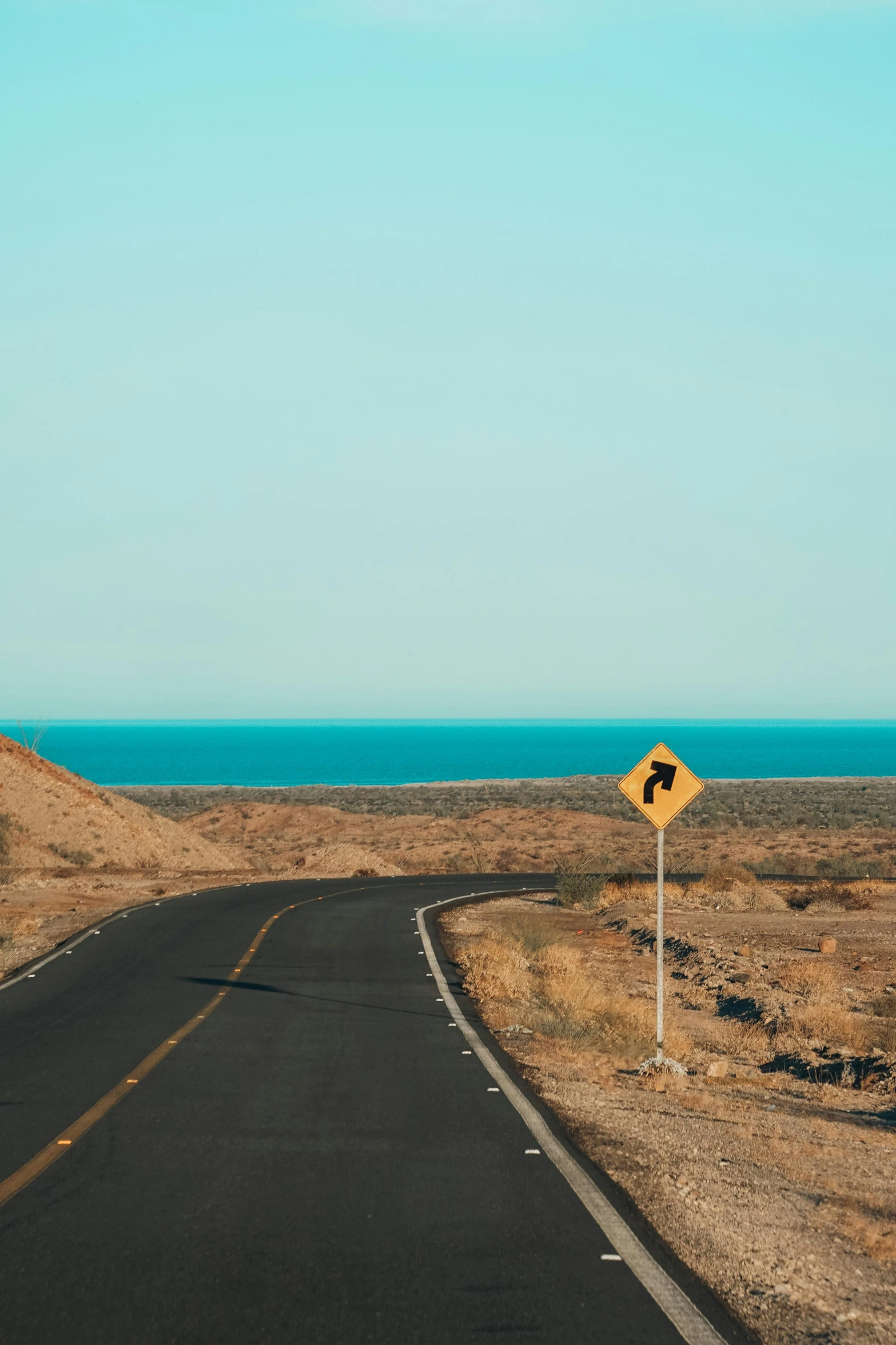 a sign with a direction of the desert and ocean