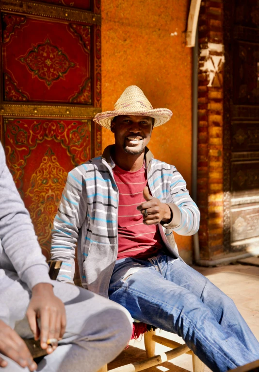 a person wearing a hat sits on a bench