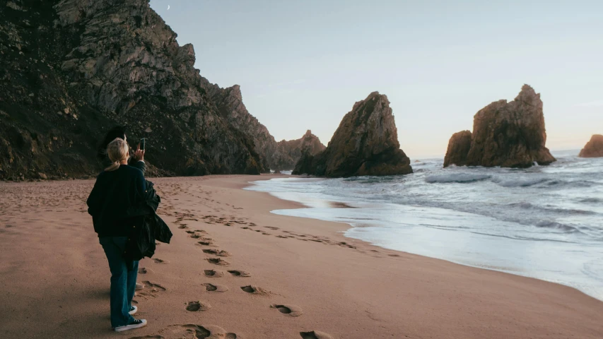 the woman walks on the sand and footprints