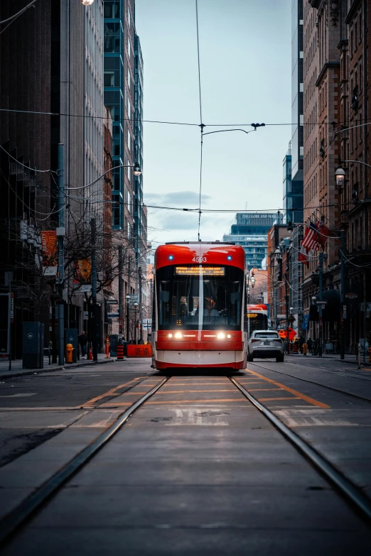 a red subway train on a city street