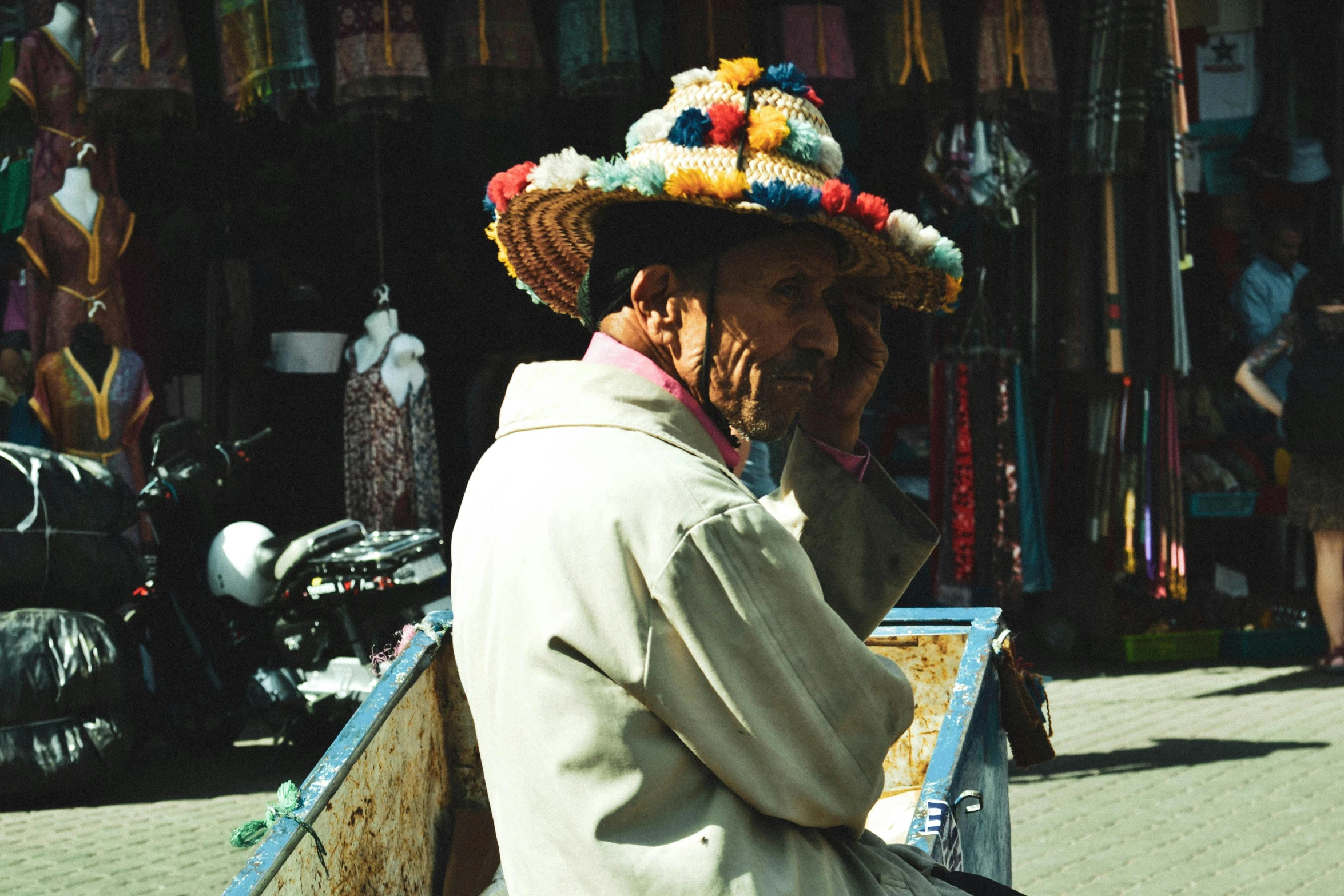 a man is wearing a colorful hat while sitting on a motorcycle