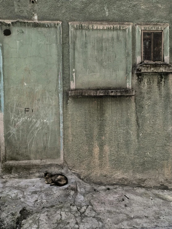 a cement wall has a window and a grate