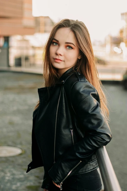 a woman with blond hair wearing a leather jacket