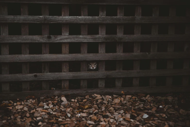 a wooden fence and gravel near rocks and gravel