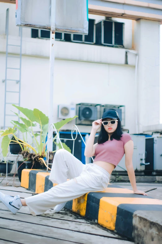 a girl in pink shirt and white pants sitting on stairs