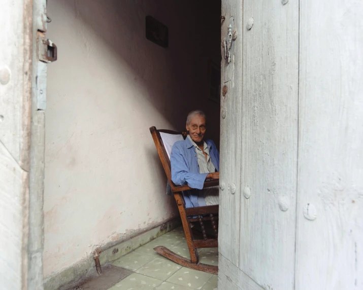 an elderly man sitting in a rocking chair