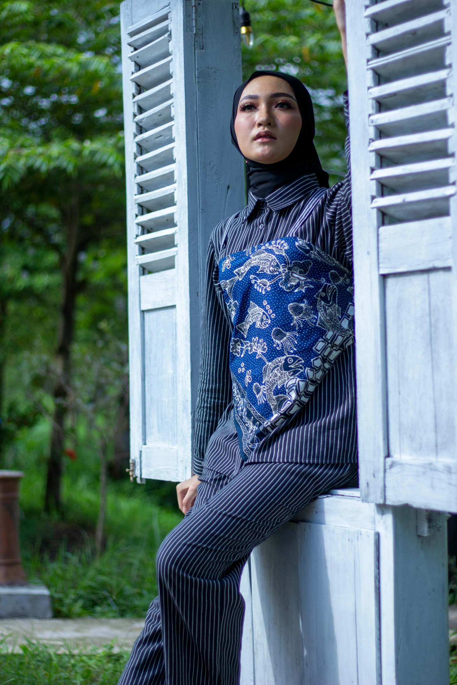 a woman is standing near a wooden window