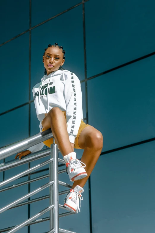 the young female is posing on top of a guardrail