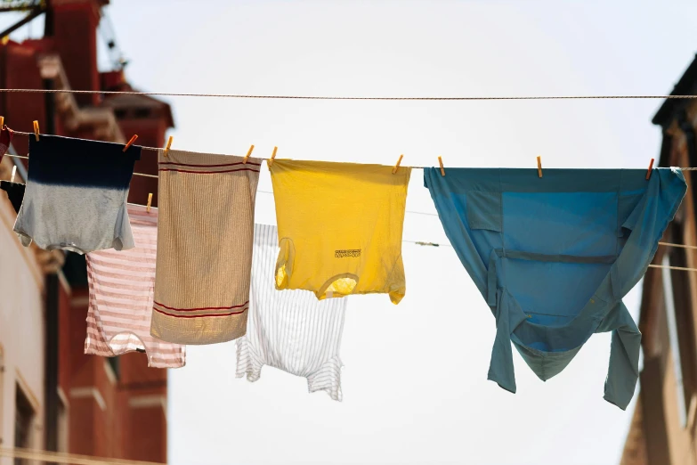 five different colored towels hanging on a clothes line