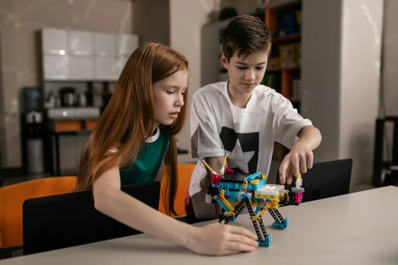 a  and girl working with legos on a table