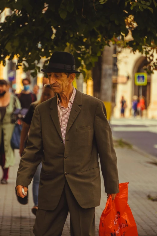 an old man is holding an orange bag