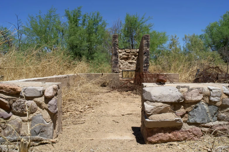 the gate into the woods is made from rocks