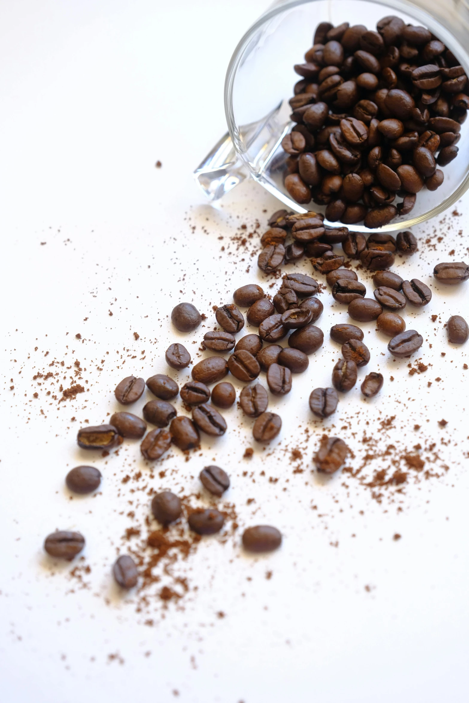 a pile of coffee beans in front of the spilled cup