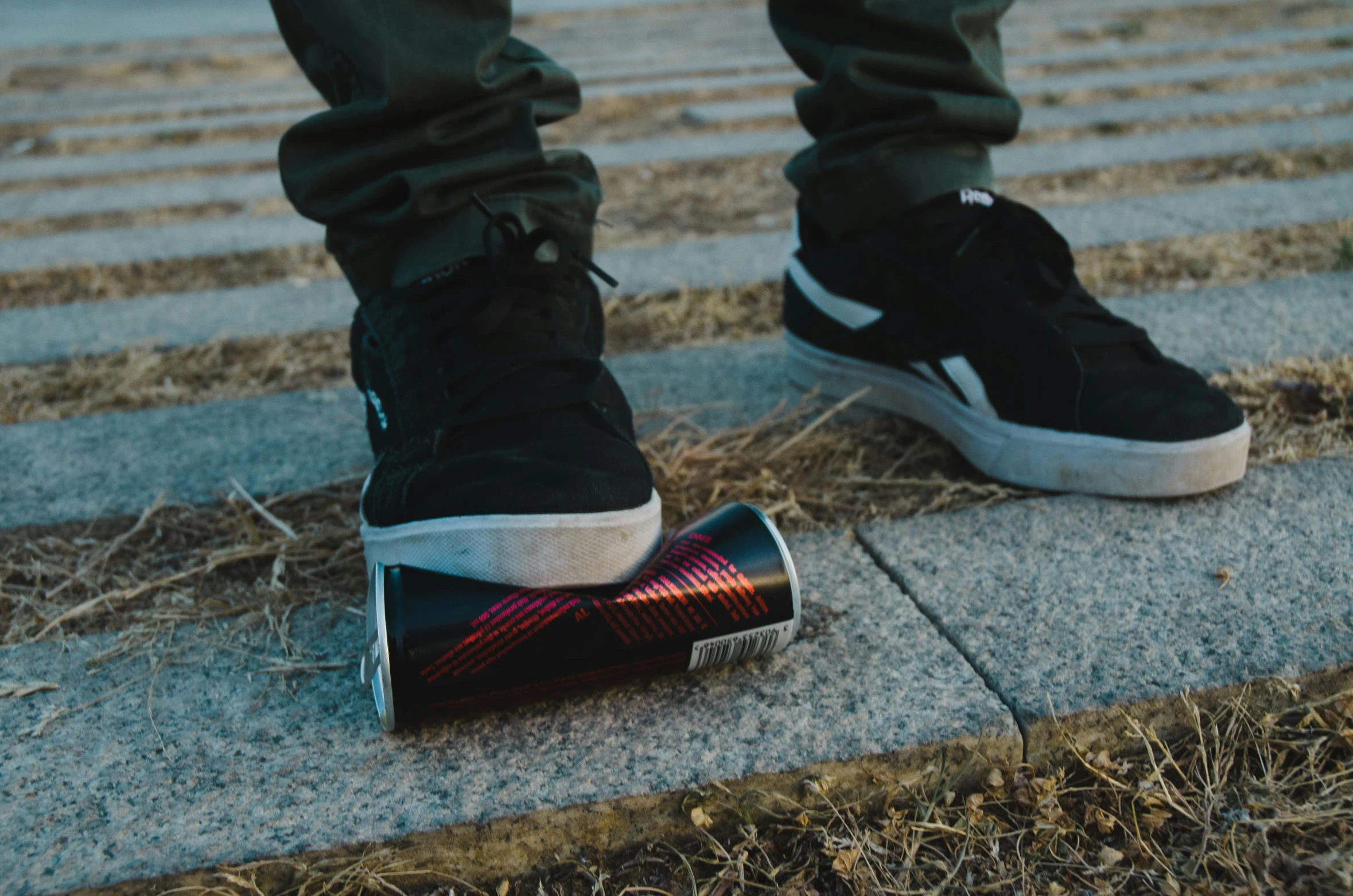 someone in black sneakers stands on the curb