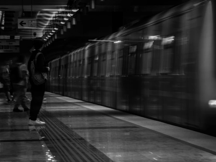 a person walking down a platform with their arms behind him